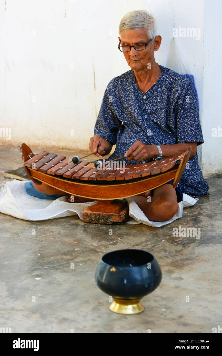 Un musicista suona il xilofono all'interno di un tempio di Sri Satchanalai Historical Park. Sukhothai provincia, Thailandia. Foto Stock