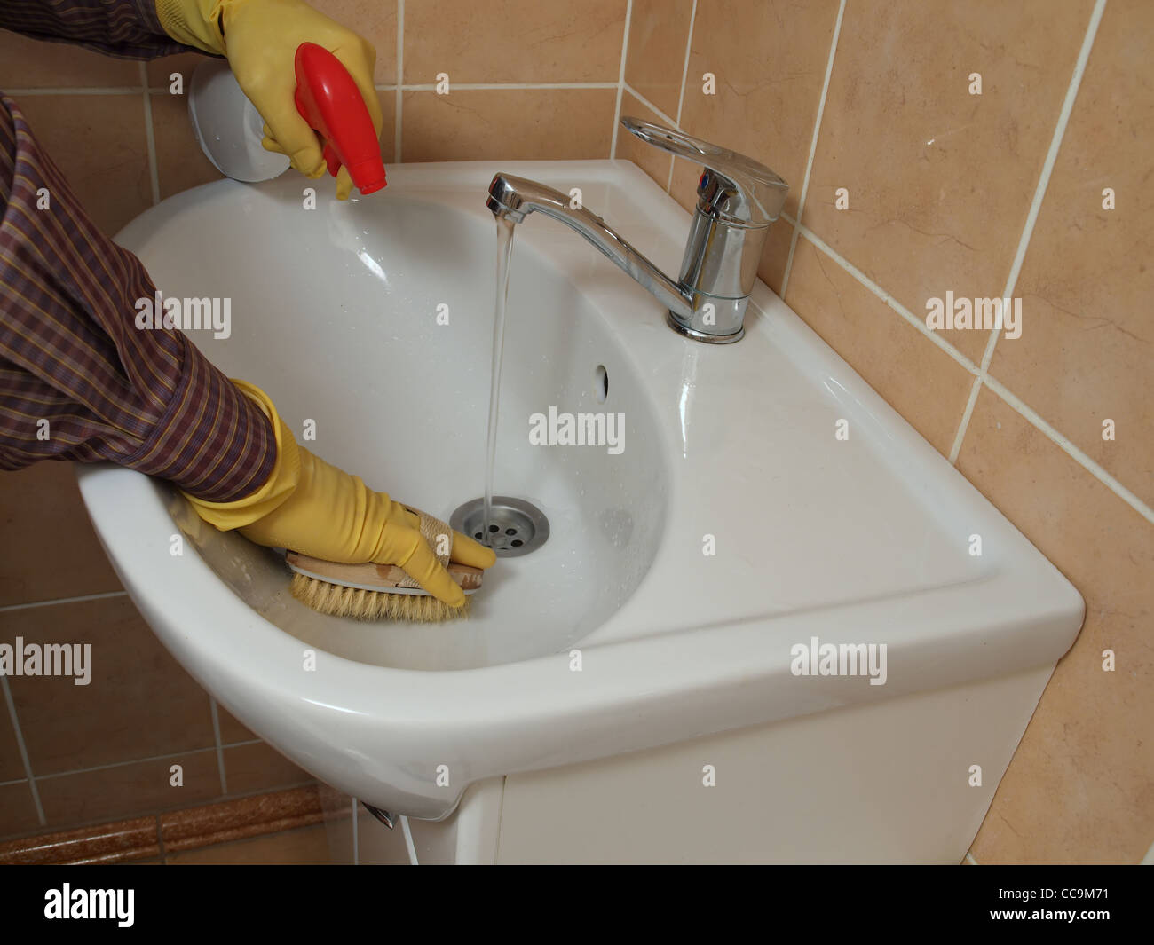 Una persona per la pulizia del lavandino del bagno con i guanti foto ... Pulizia del bagno