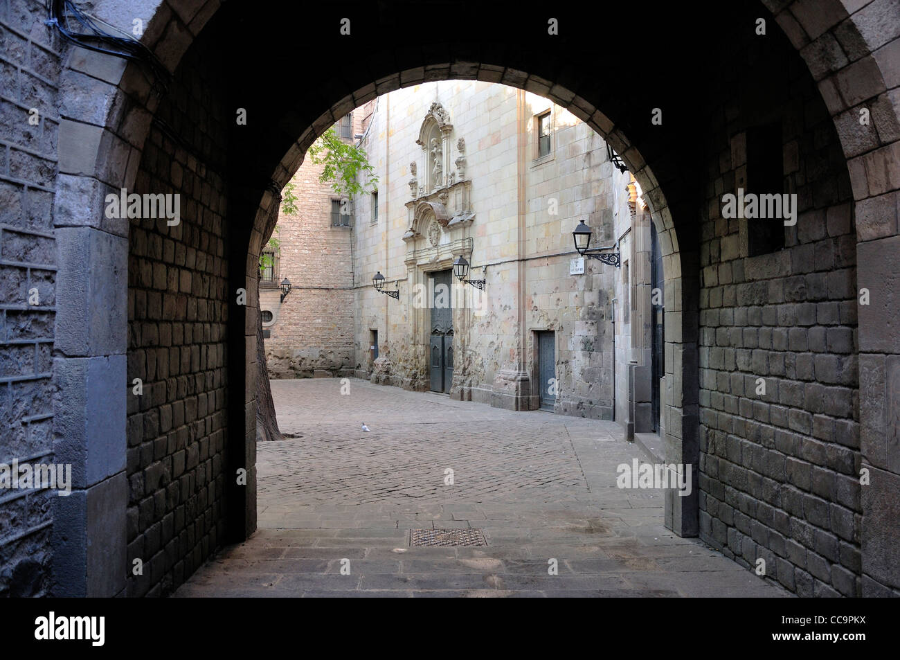 Barcellona, Spagna. Plaça de Sant Felip Neri. Passaruota attraverso alla chiesa Foto Stock