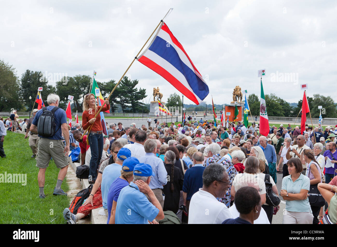 Una donna sventola una bandiera tailandese alla pace mondiale rally Foto Stock