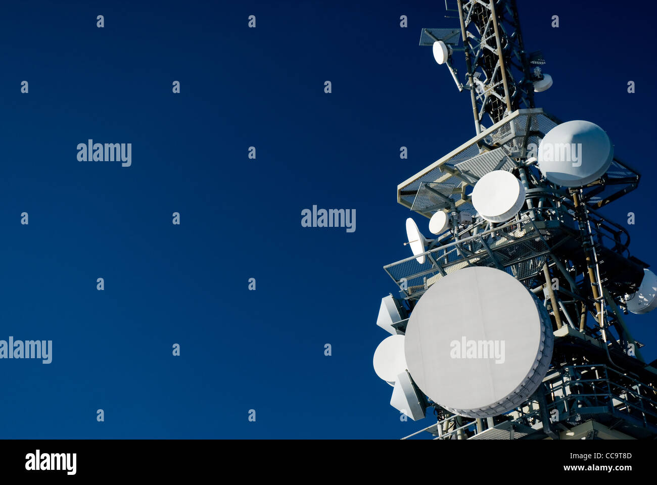 Una torre di comunicazione sul profondo blu del cielo. Foto Stock