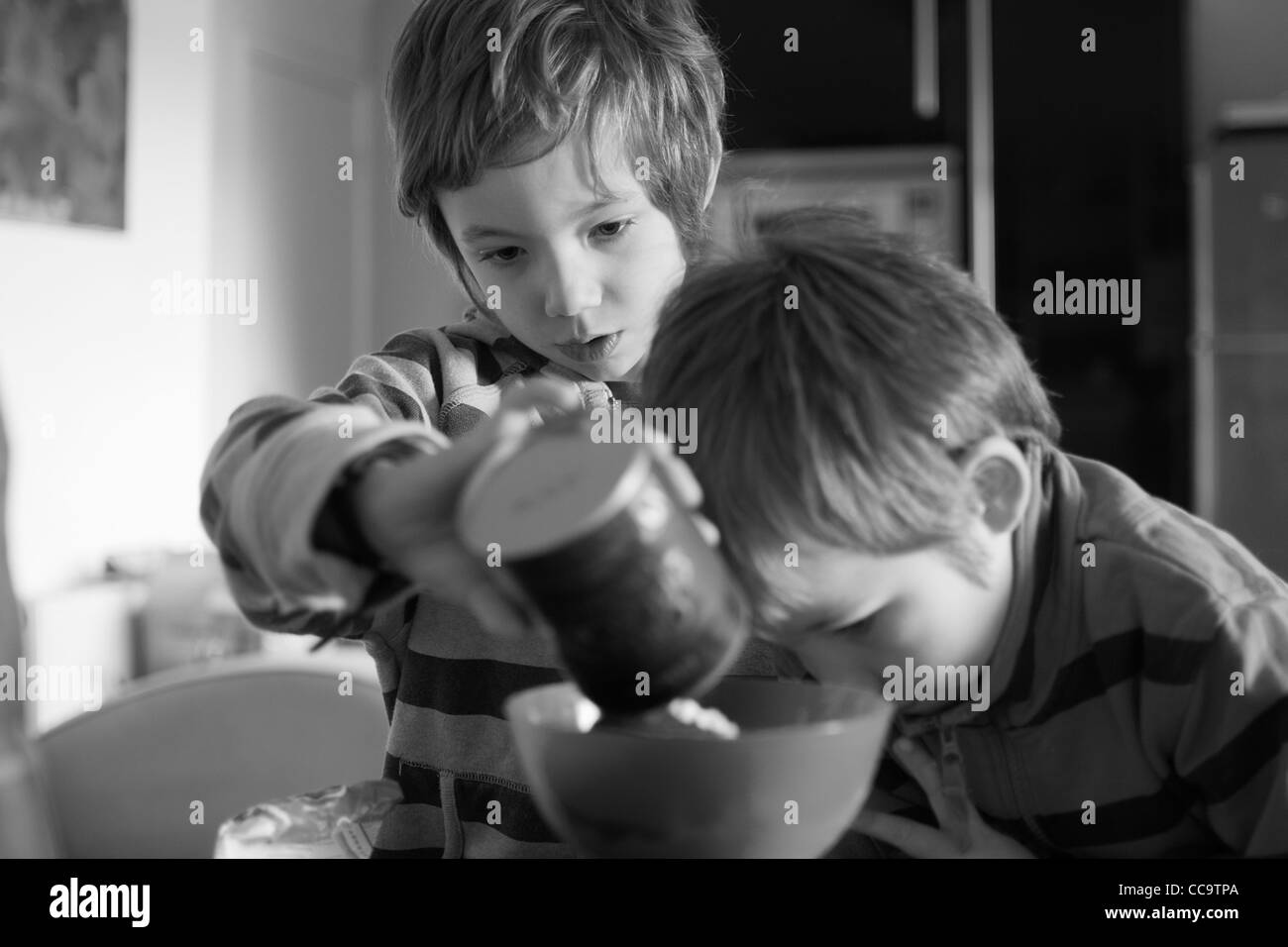 Due bambini di cottura di una torta al cioccolato insieme Foto Stock