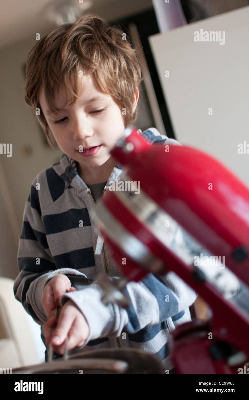 Giovane ragazzo in cucina facendo una torta al cioccolato. Foto Stock