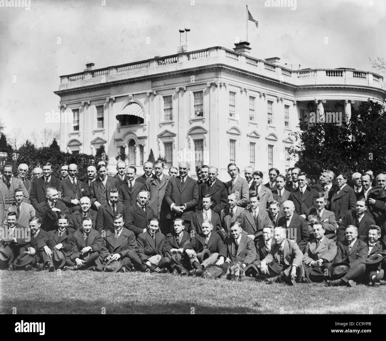 Presidente Harding, in piedi sul prato della Casa Bianca con un grande gruppo di newspapermen seduti e in piedi intorno a lui.1921 Foto Stock