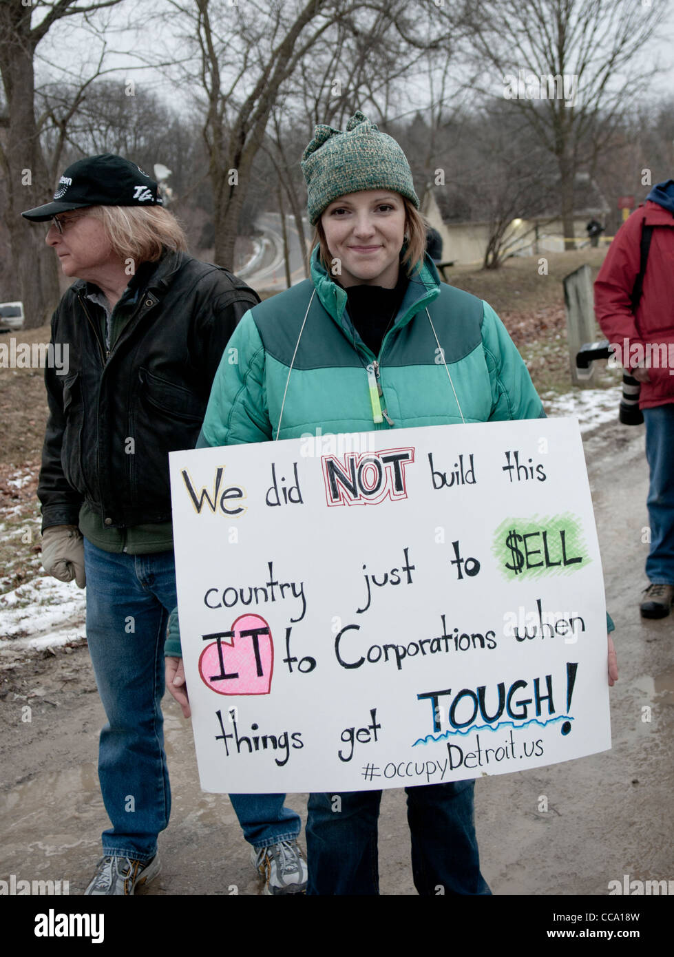 Protester in Ann Arbor Michigan gennaio 16 2012 tenendo un cartello. A Martin Luther King giorno marzo al Governatore Rick Snyder's home Foto Stock