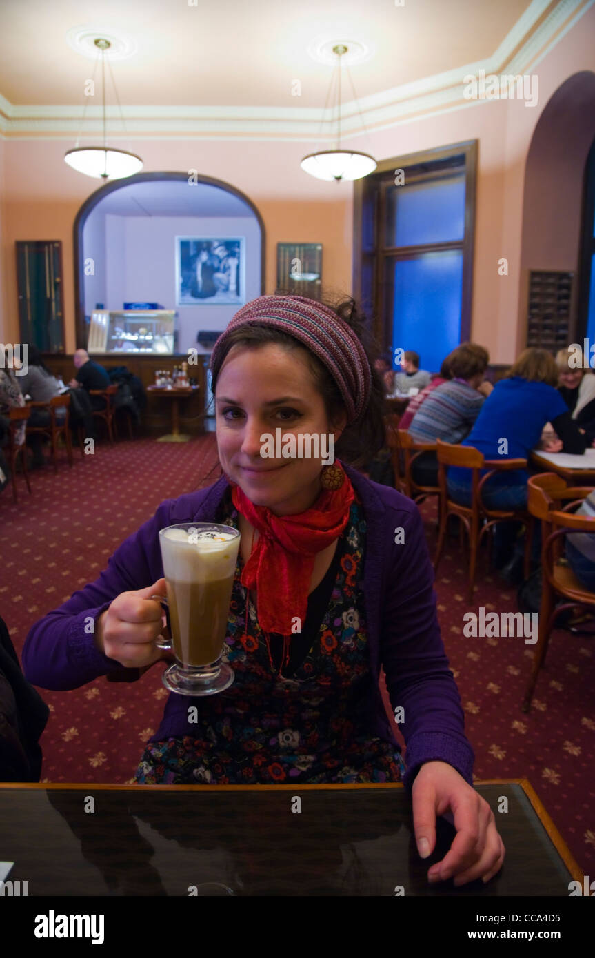 Turista nella sua 20s avente un irish coffee Cafe Louvre centro di Praga Repubblica Ceca Europa Foto Stock