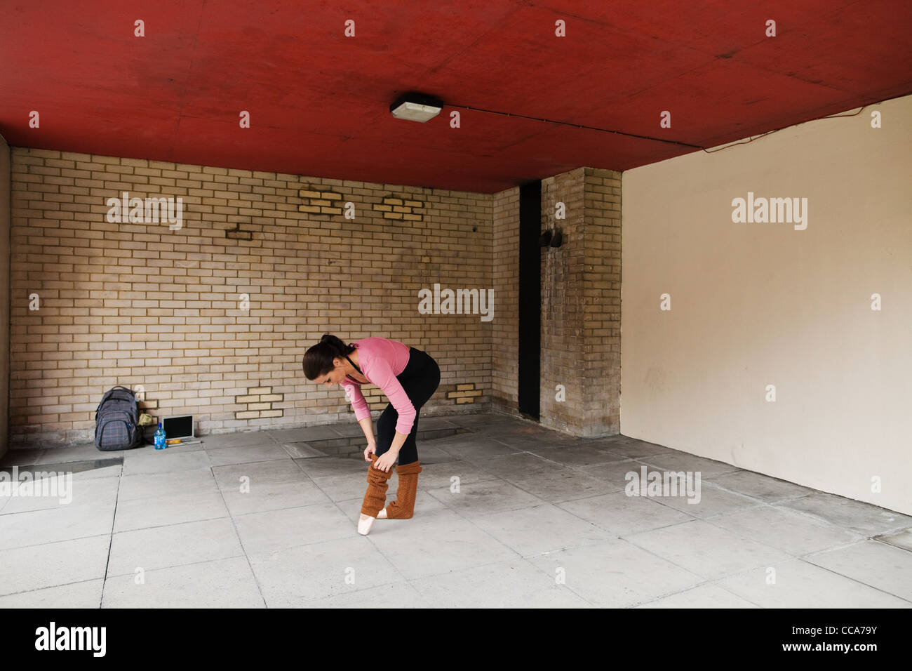 Donna gamba regolazione scaldabiberon prima di lavorare fuori Foto Stock