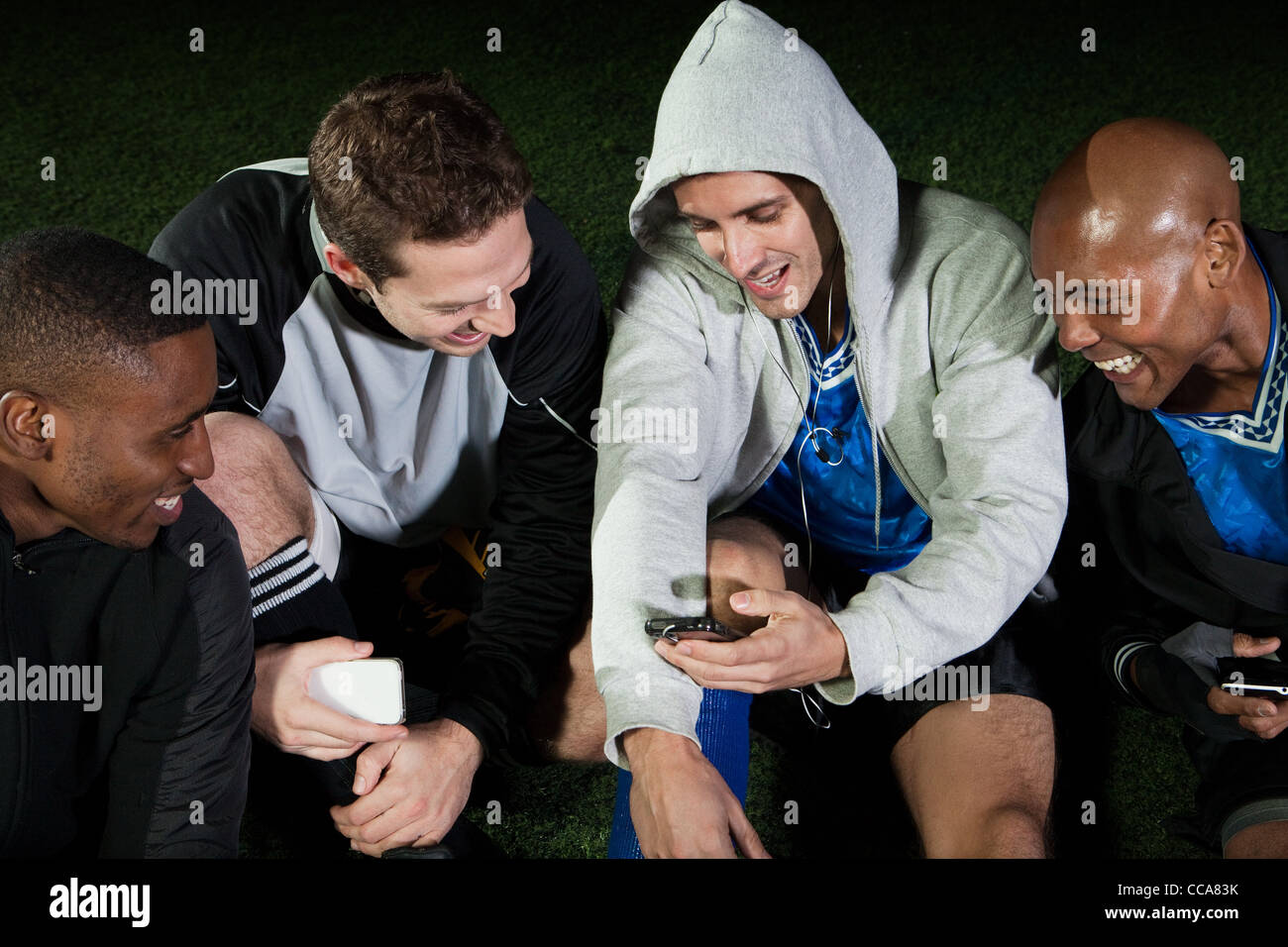 I giocatori di calcio guardando il cellulare del passo Foto Stock