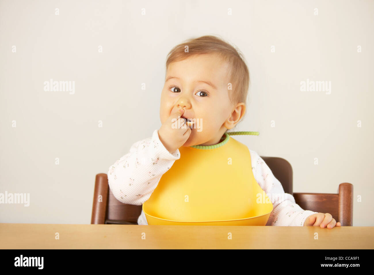 Baby girl di mangiare con la mano Foto Stock
