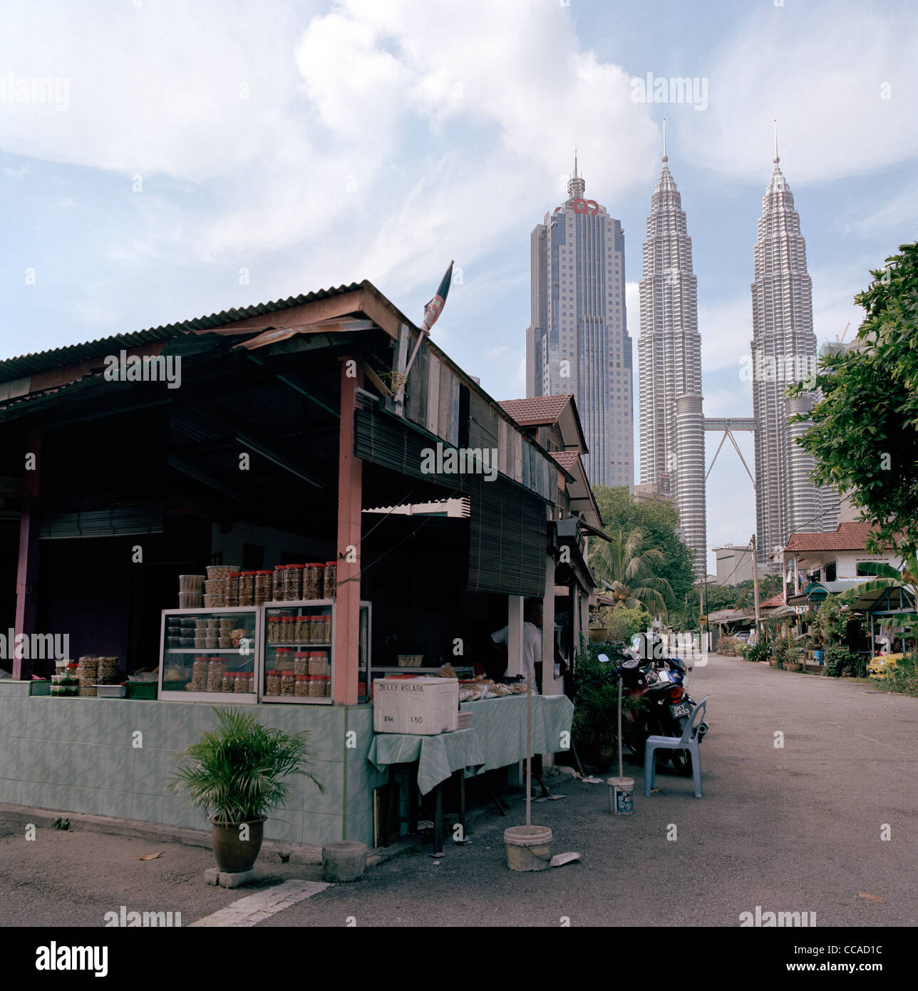 Il tramonto e la notte scende come le Torri Petronas incombono su di Kampung Baru nella città di Kuala Lumpur in Malesia in Estremo Oriente Asia sud-orientale. Città Travel Foto Stock