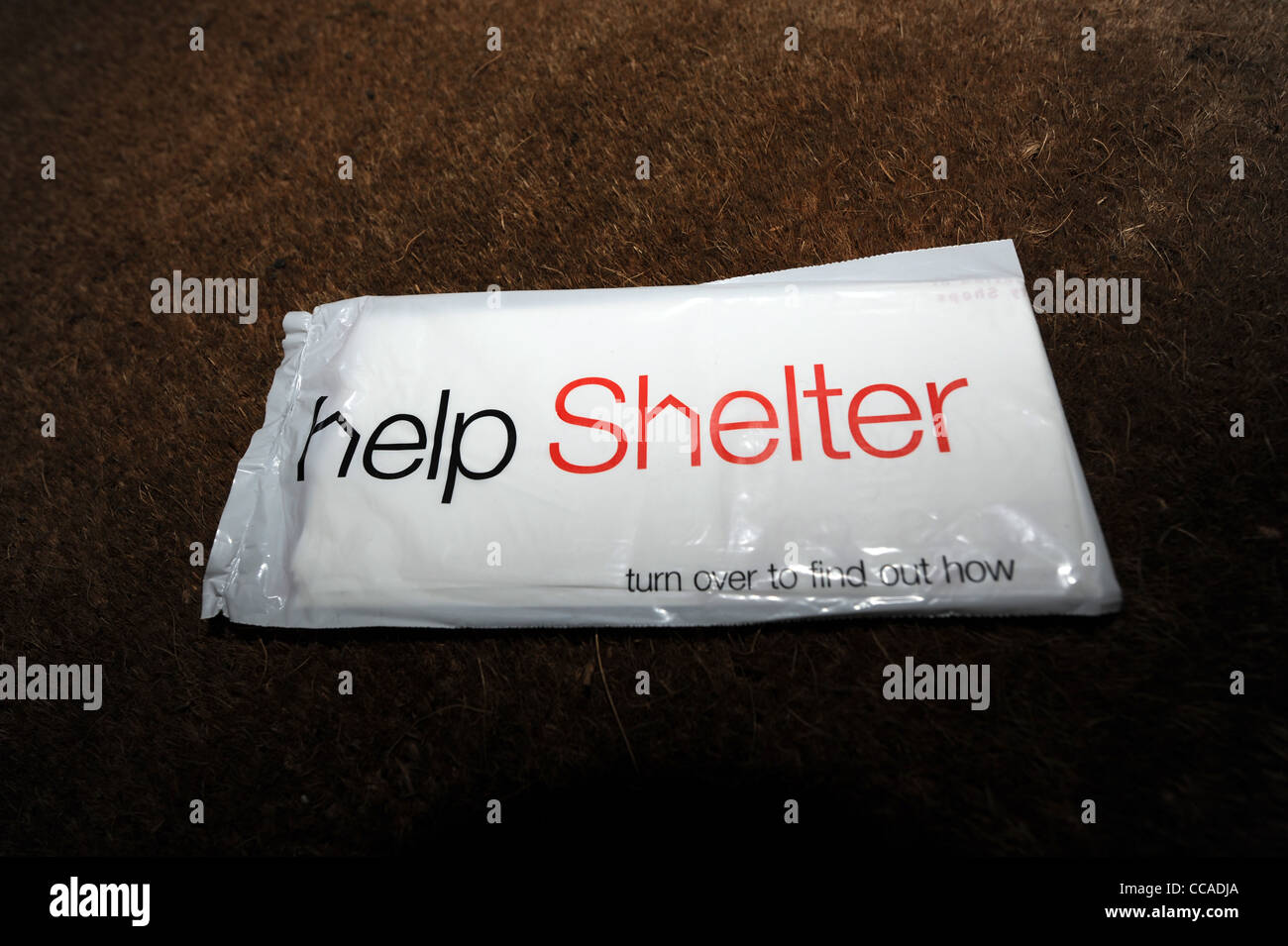 Help Shelter carità sacchetto di raccolta essendo inviato attraverso una cassetta delle lettere della casa britannica per i proprietari di dare via vestiti indesiderati Foto Stock