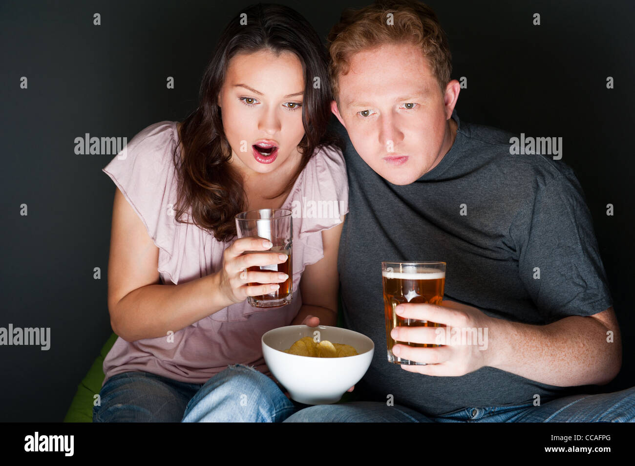 Un paio di guardare un film di paura e si ha paura di loro così tanto che sono urlando. Foto Stock