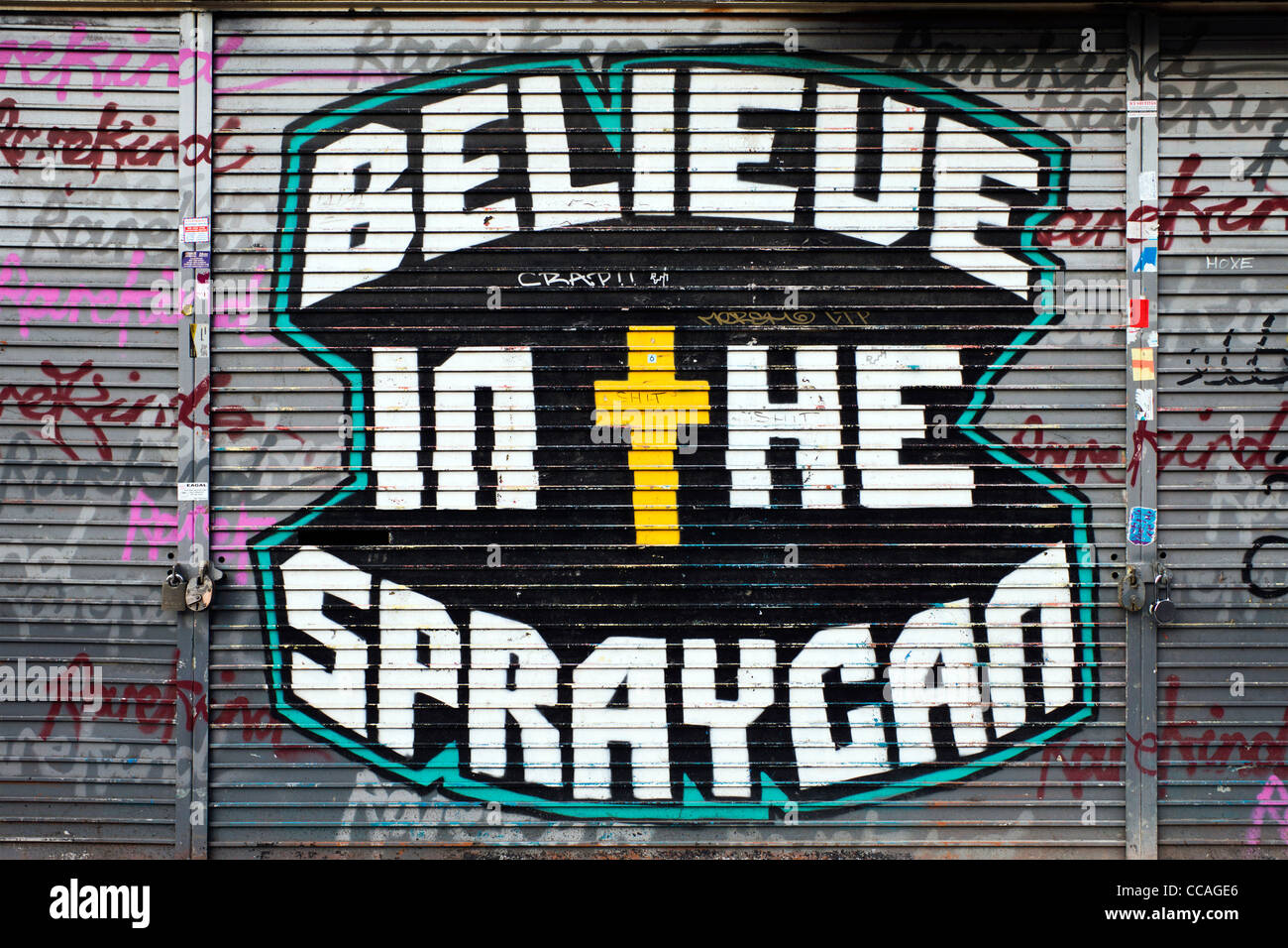 Credo nell'Spraycan graffiti su un Shoreditch shop otturatore Foto Stock
