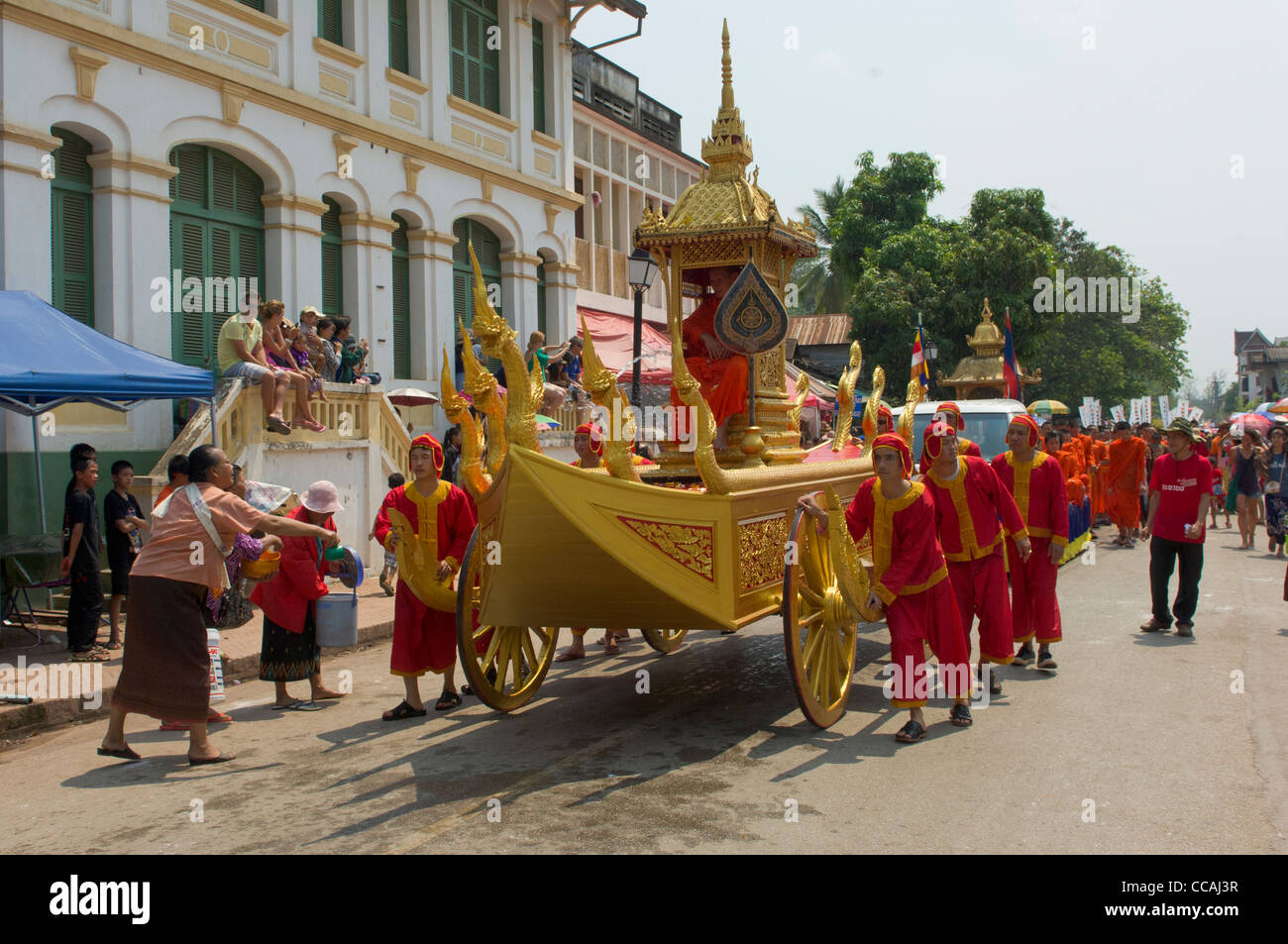 Abate buddista essendo spinto in un carro d'oro in processione, sul Mue Nau, Lao Anno Nuovo (Pi Mai Lao), Luang Prabang, Laos Foto Stock