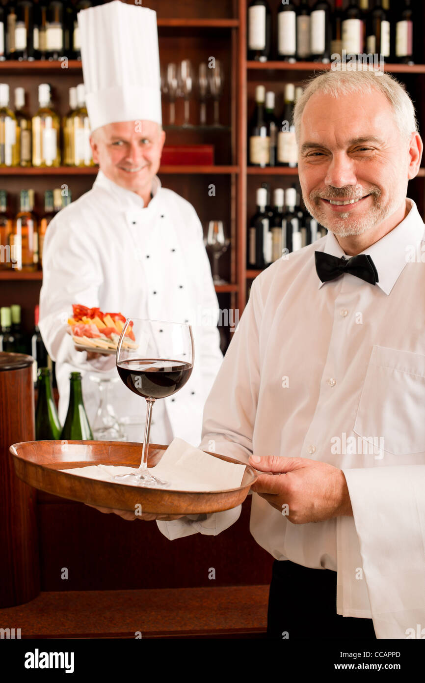 Chef di cucina con tapas cameriere servono sul vassoio in ristorante Foto Stock