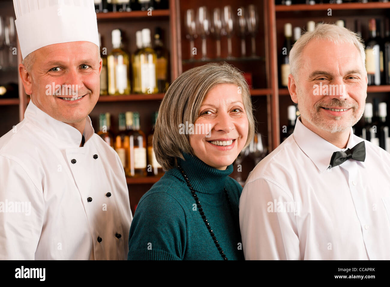 Il manager del ristorante in posa con chef di cucina e cameriere wine bar Foto Stock