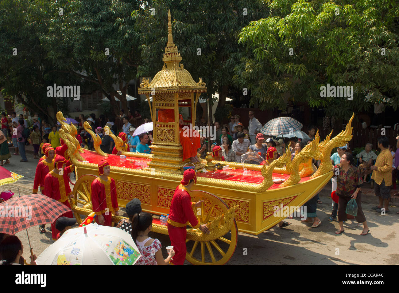 Abate buddista essendo spinto in un carro d'oro in processione, Mue Nau, Lao Anno Nuovo (Pi Mai Lao), Luang Prabang, Laos Foto Stock
