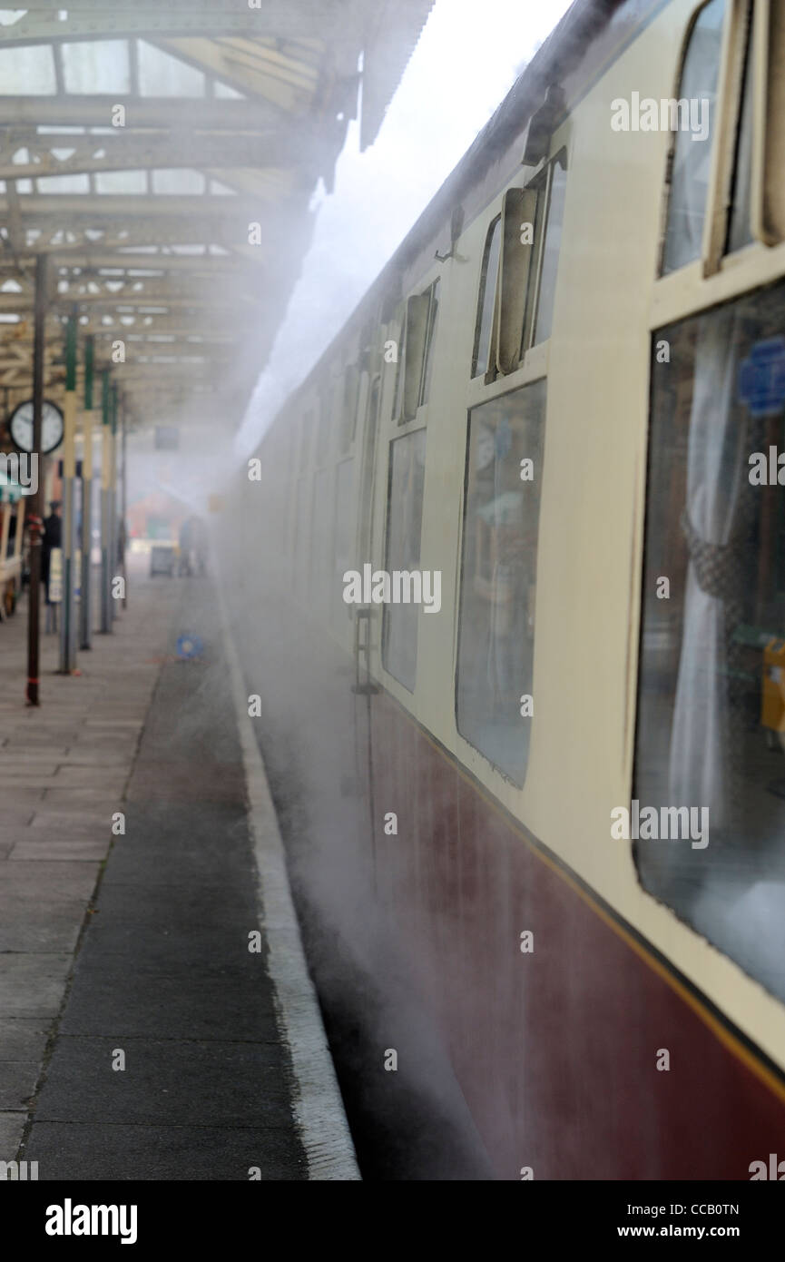 Il vapore proveniente da sotto il vagone ferroviario grande stazione centrale ferroviaria loughborough England Regno Unito Foto Stock