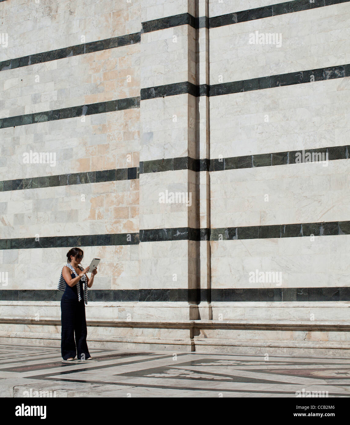 Una donna con il suo ipad Apple per scattare foto al di fuori della cattedrale, Siena. L'Italia. Foto Stock
