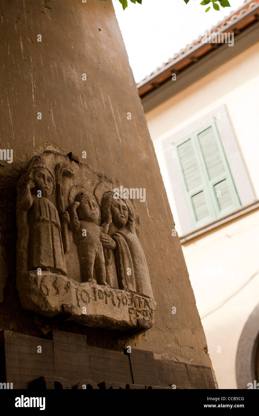 Plinto scolpita in rilievo di una famiglia su una parete in Orvieto, Italia. Foto Stock