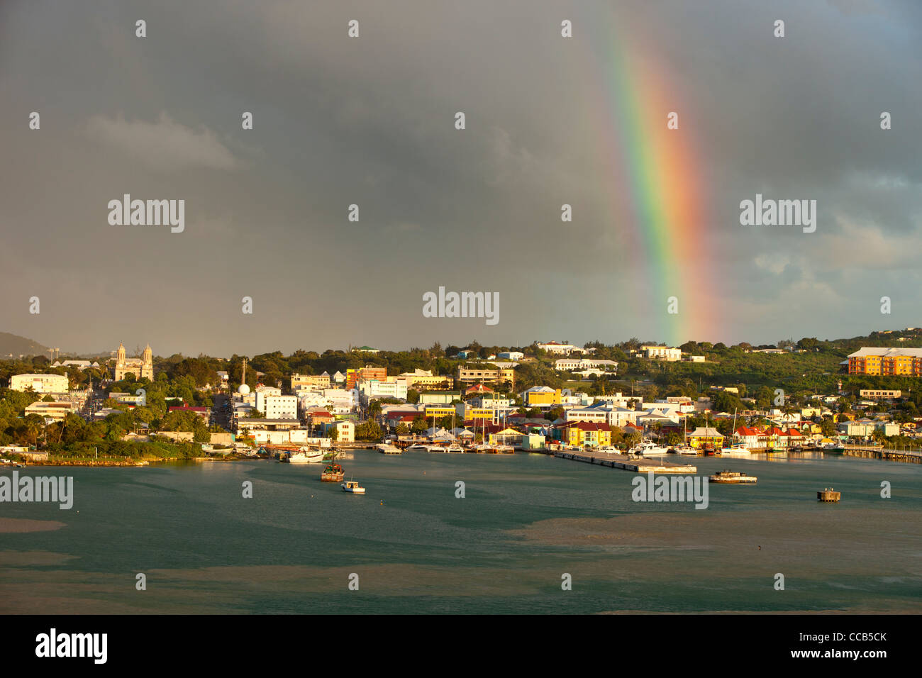 Rainbow appare sopra la città di St. Johns sull'isola caraibica di Antigua, West Indies Foto Stock