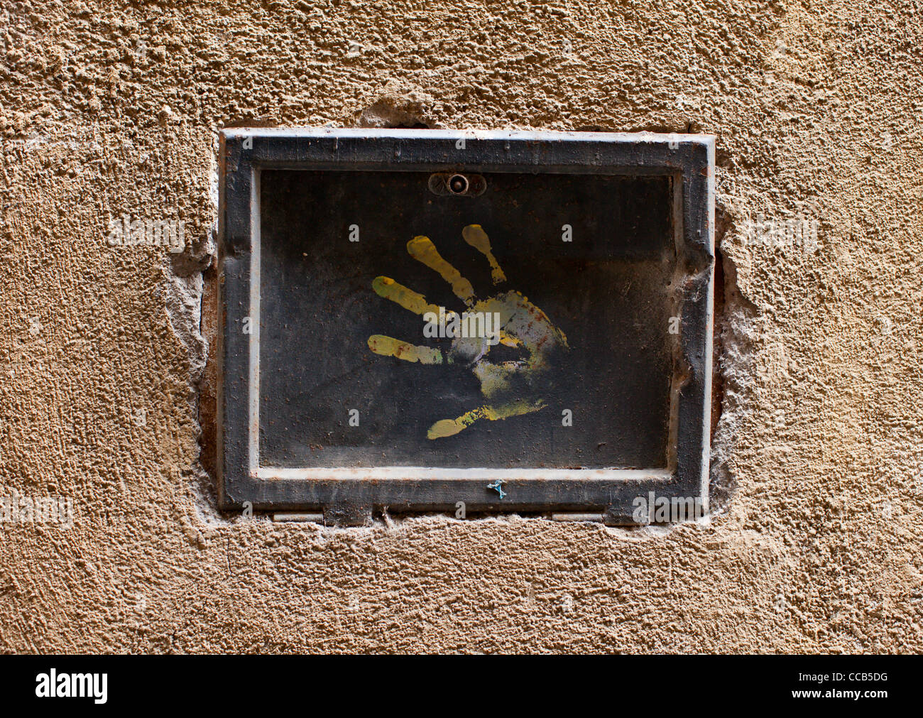 Un fusibile di elettricità scatola incassata in una parete di gesso con una mano sulla stampa. Orvieto, Italia. Foto Stock