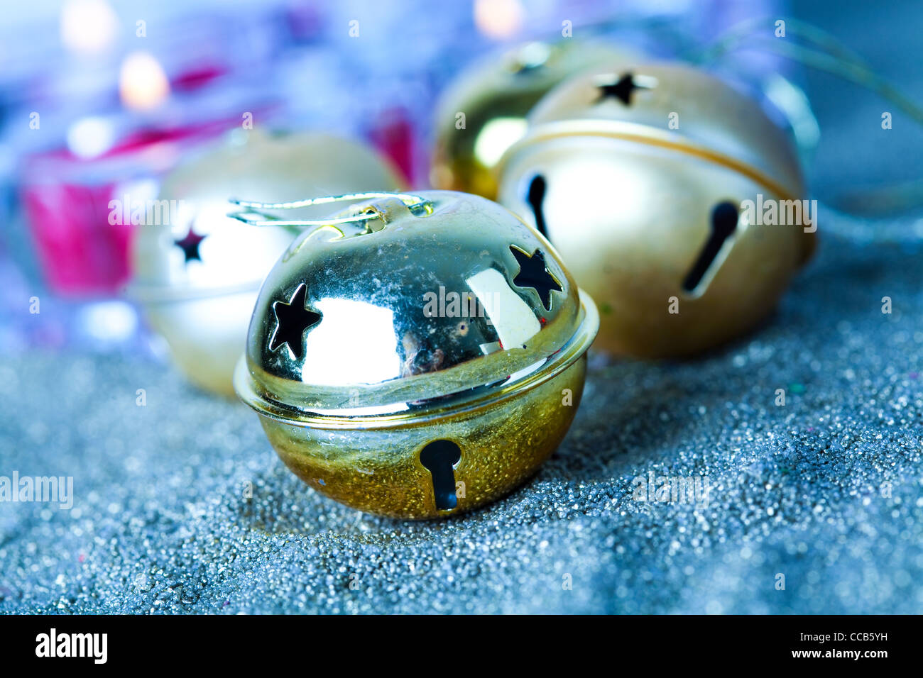 Close-up di golden jingle bell baubles di Natale con le candele Foto Stock