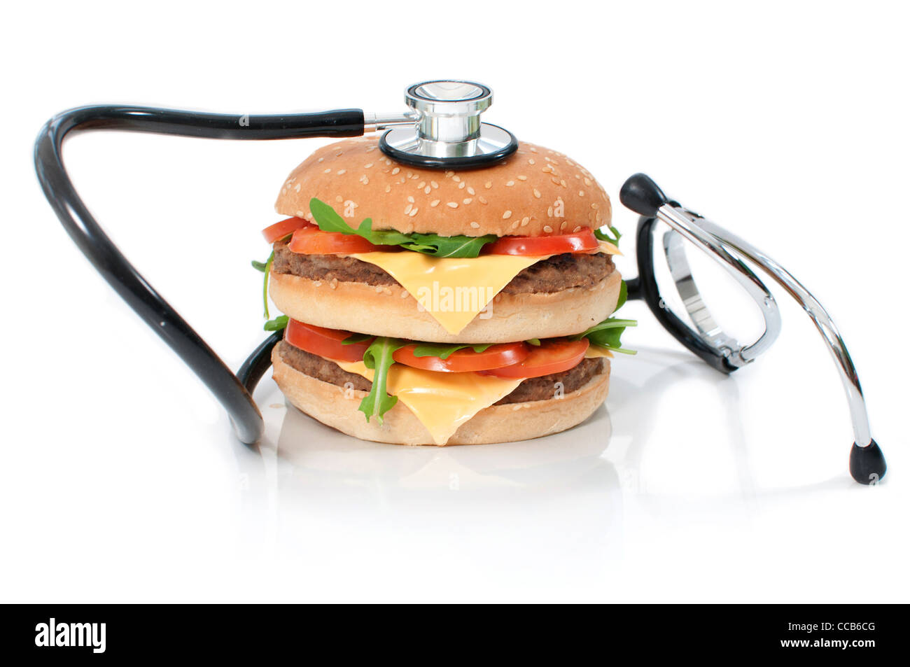 Uno stetoscopio intorno a una malsana double cheeseburger Foto Stock