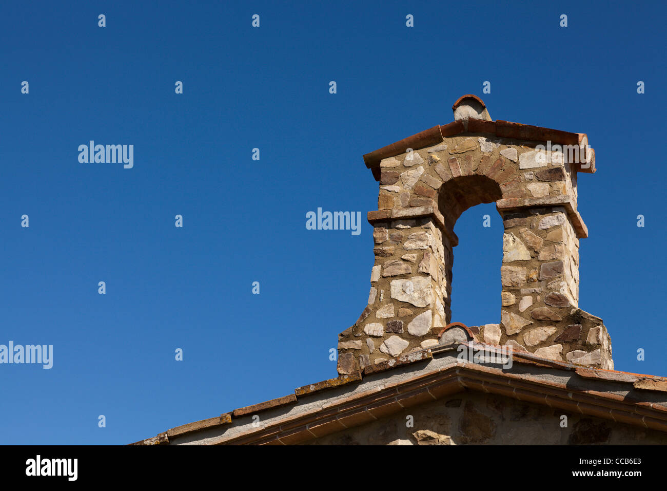 Una piccola torre campanaria meno la campana su un tipico tetto umbra. Marsciano, Umbria, Italia. Foto Stock