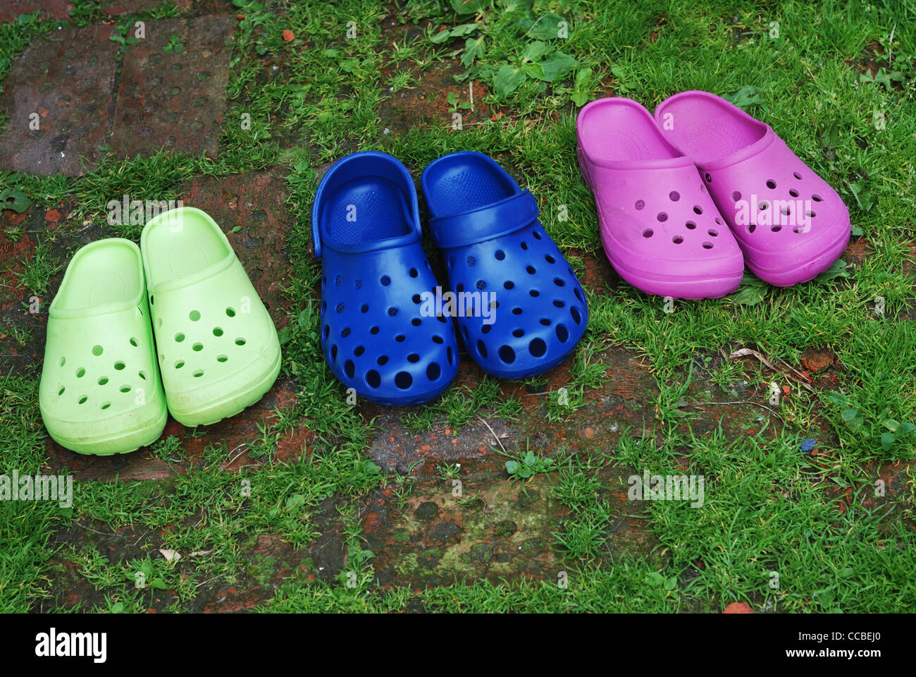 Tre paia di pantofole di gomma in erba Foto Stock