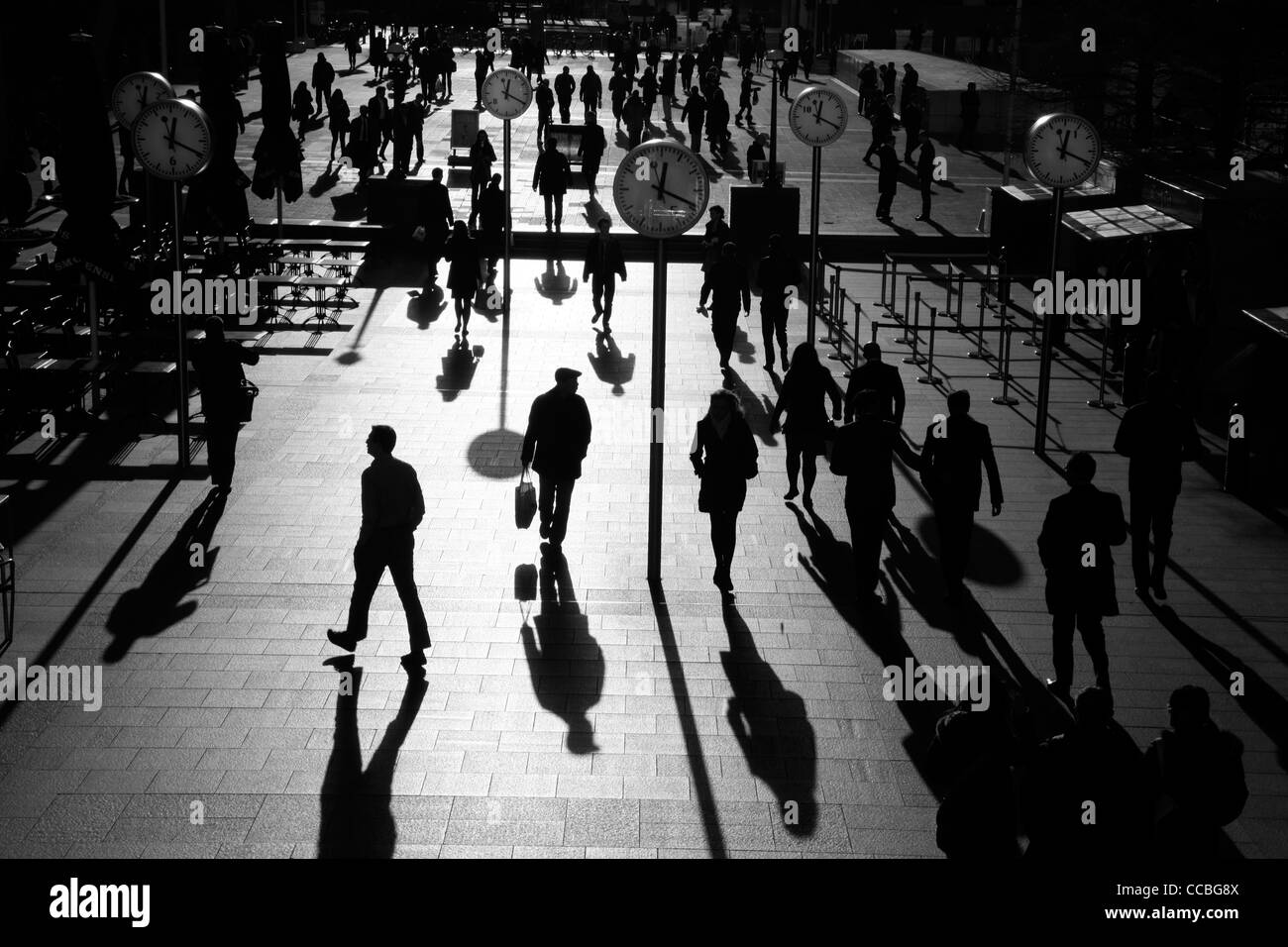 Ombre e sagome di pedoni a piedi attraverso Reuters Plaza, Canary Wharf, London, Regno Unito Foto Stock