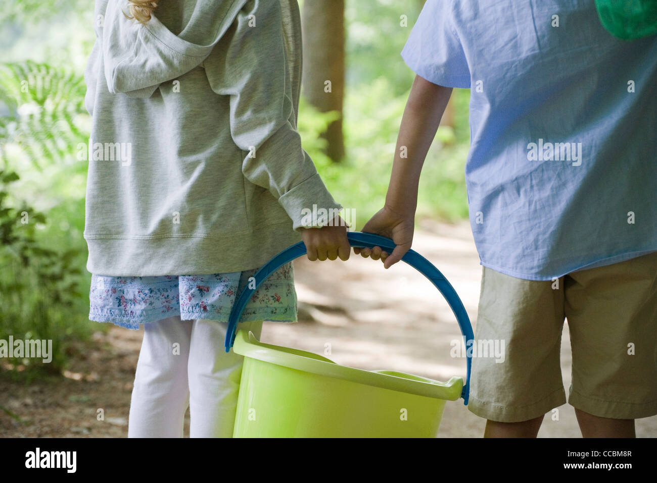 Bambini che portano insieme benna, ritagliato Foto Stock