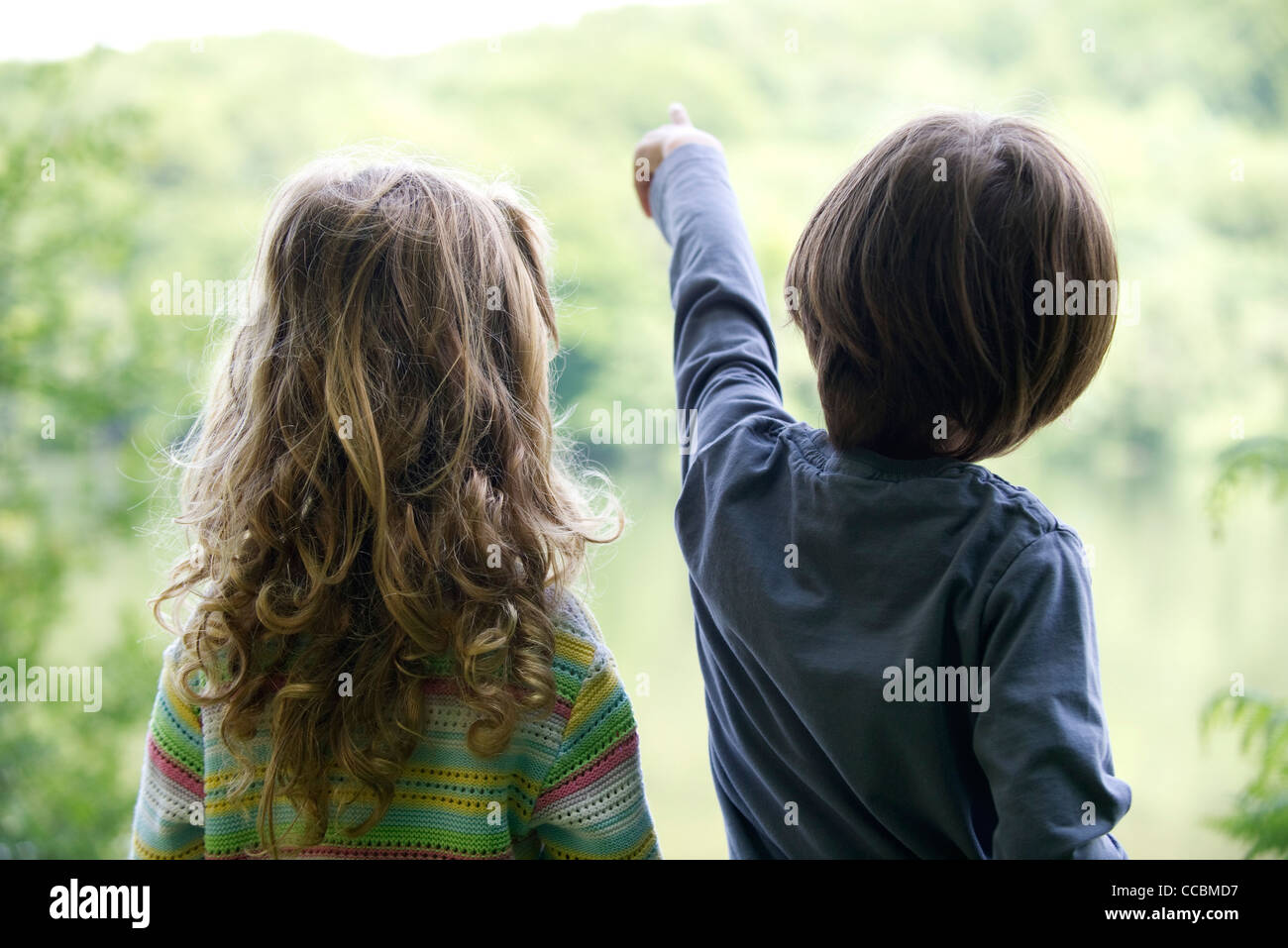 I bambini guardando il lago come punti di boy Foto Stock