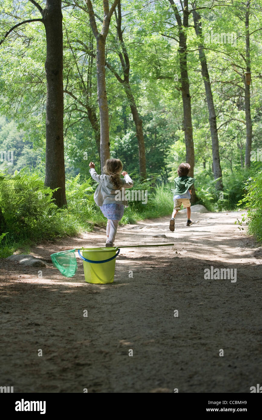 I bambini in esecuzione sul percorso attraverso i boschi Foto Stock