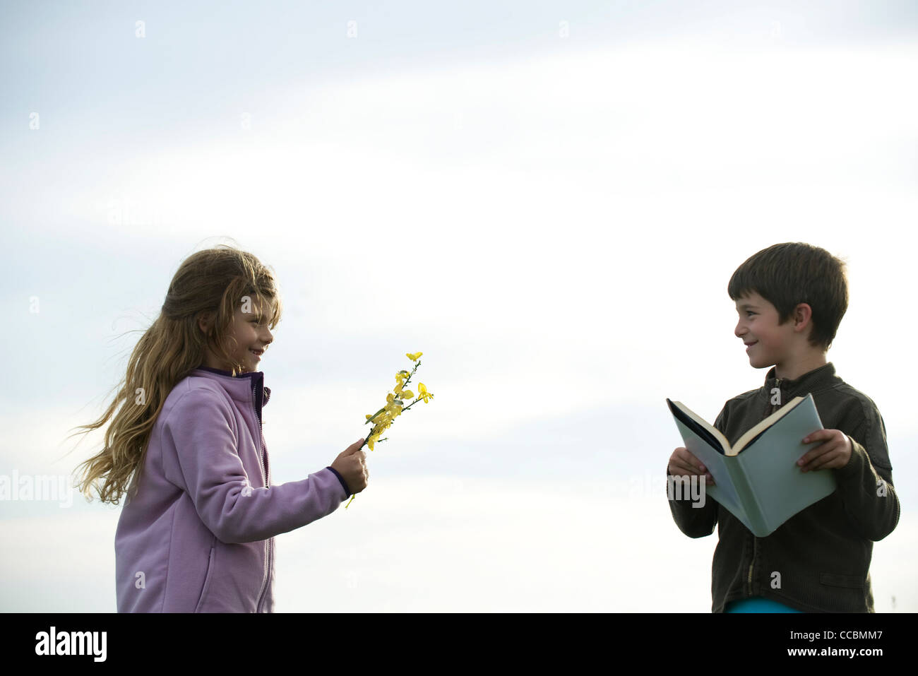 Ragazza ragazzo dando fiori selvatici Foto Stock
