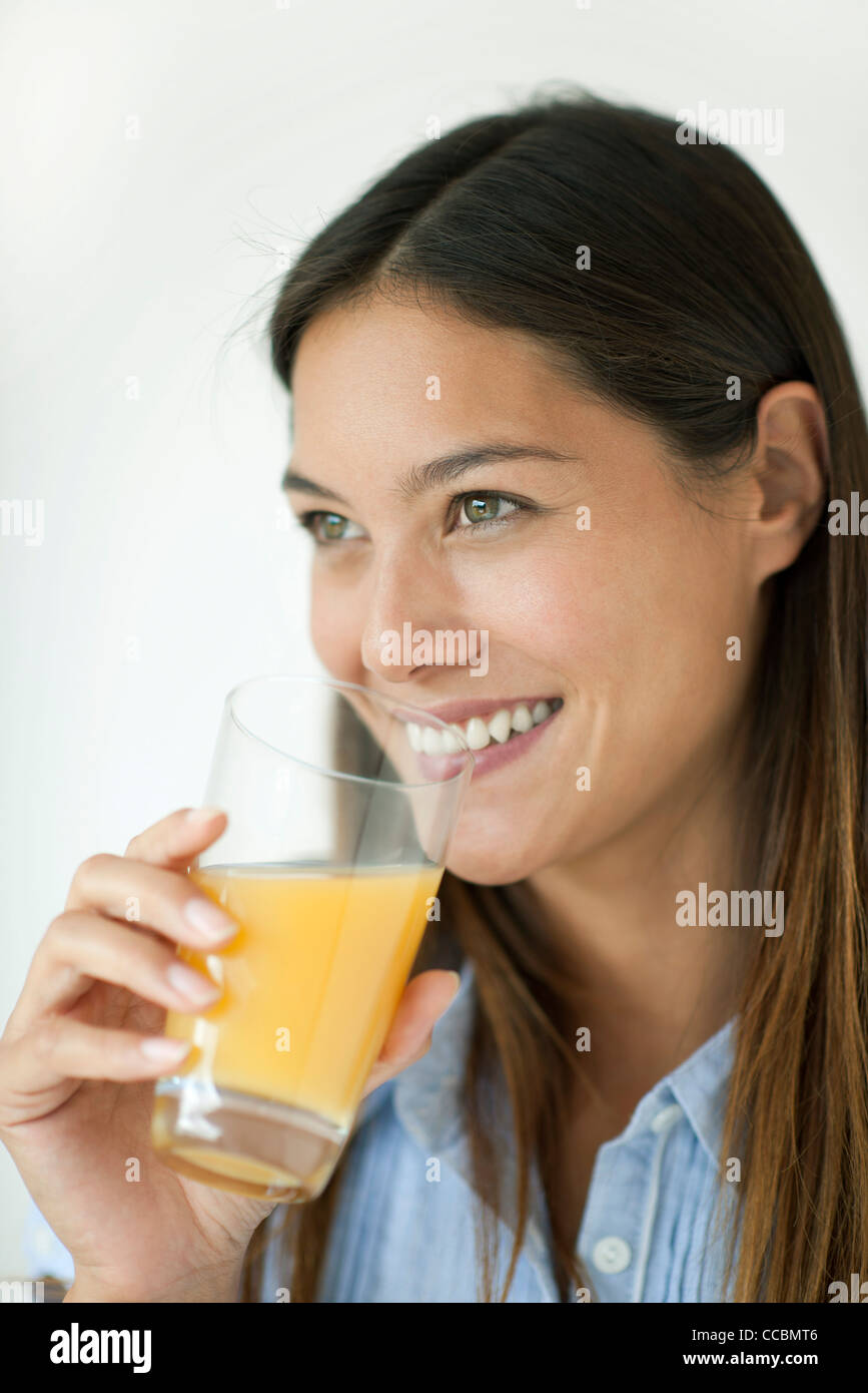 Giovane donna di bere succo di arancia Foto Stock