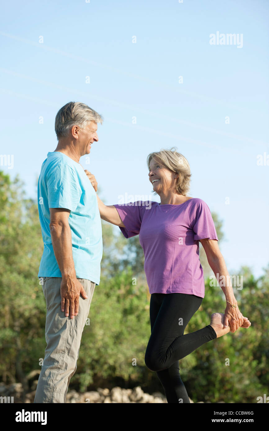 Coppia senior all'aperto, donna azienda all'uomo per supporto durante lo stiramento Foto Stock