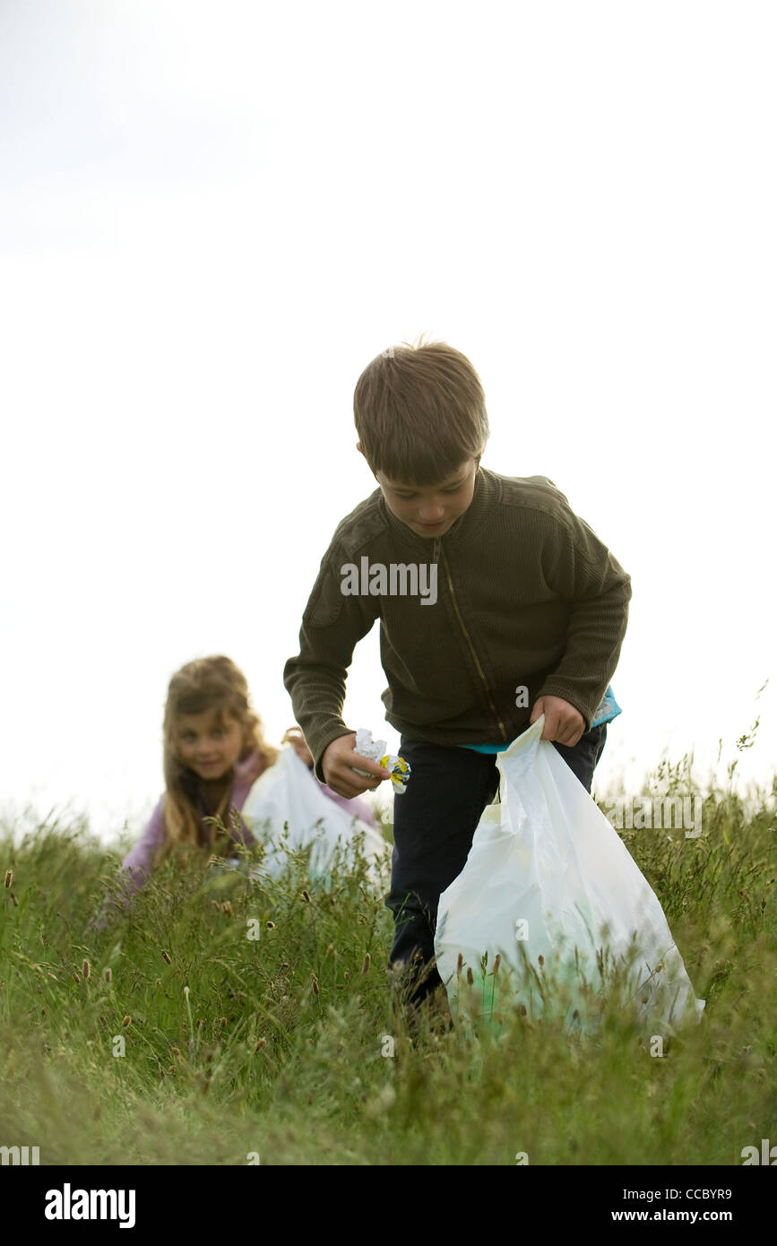 Bambini il prelievo del cestino nel campo Foto Stock