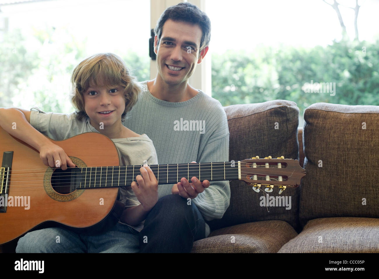 Padre figlio di insegnamento come suonare la chitarra Foto Stock