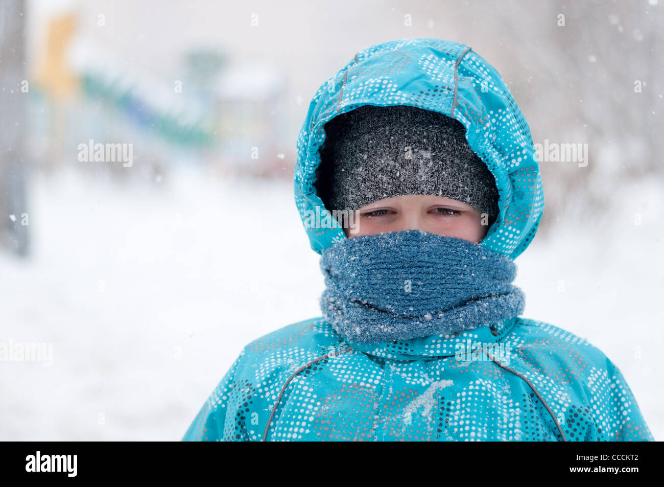 Bambino ritratto uno a otto anni abbigliamento invernale blizzard gelo della neve down jacket cofano sciarpa blu freddo giorno guarda a destra la Russia n. Foto Stock