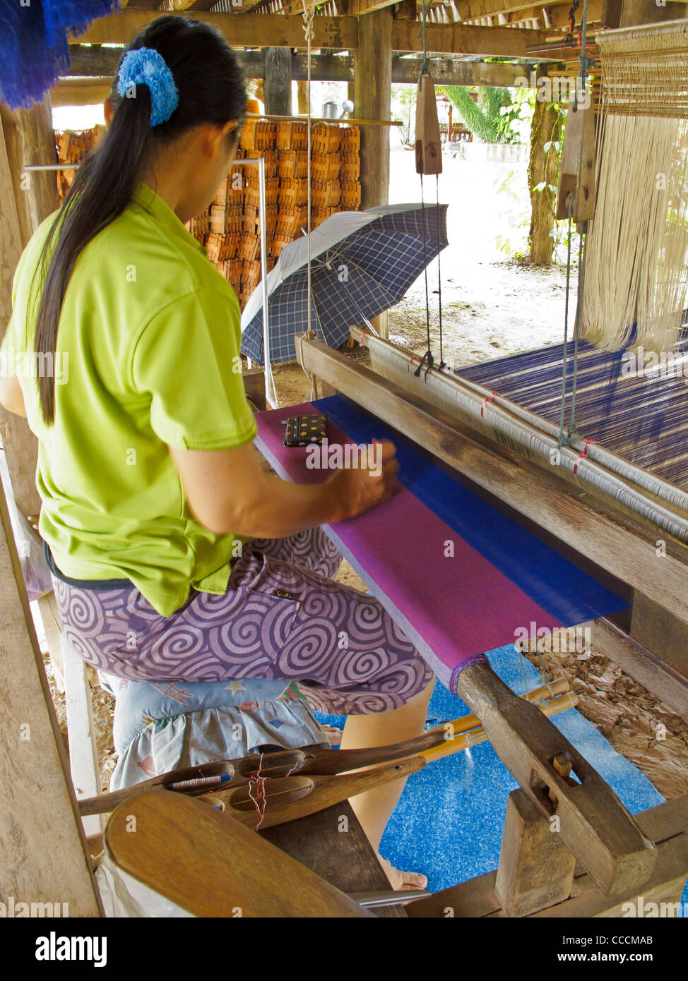 Un Thai Lue (Tai lu) donna è la tessitura sul suo telaio. Foto Stock