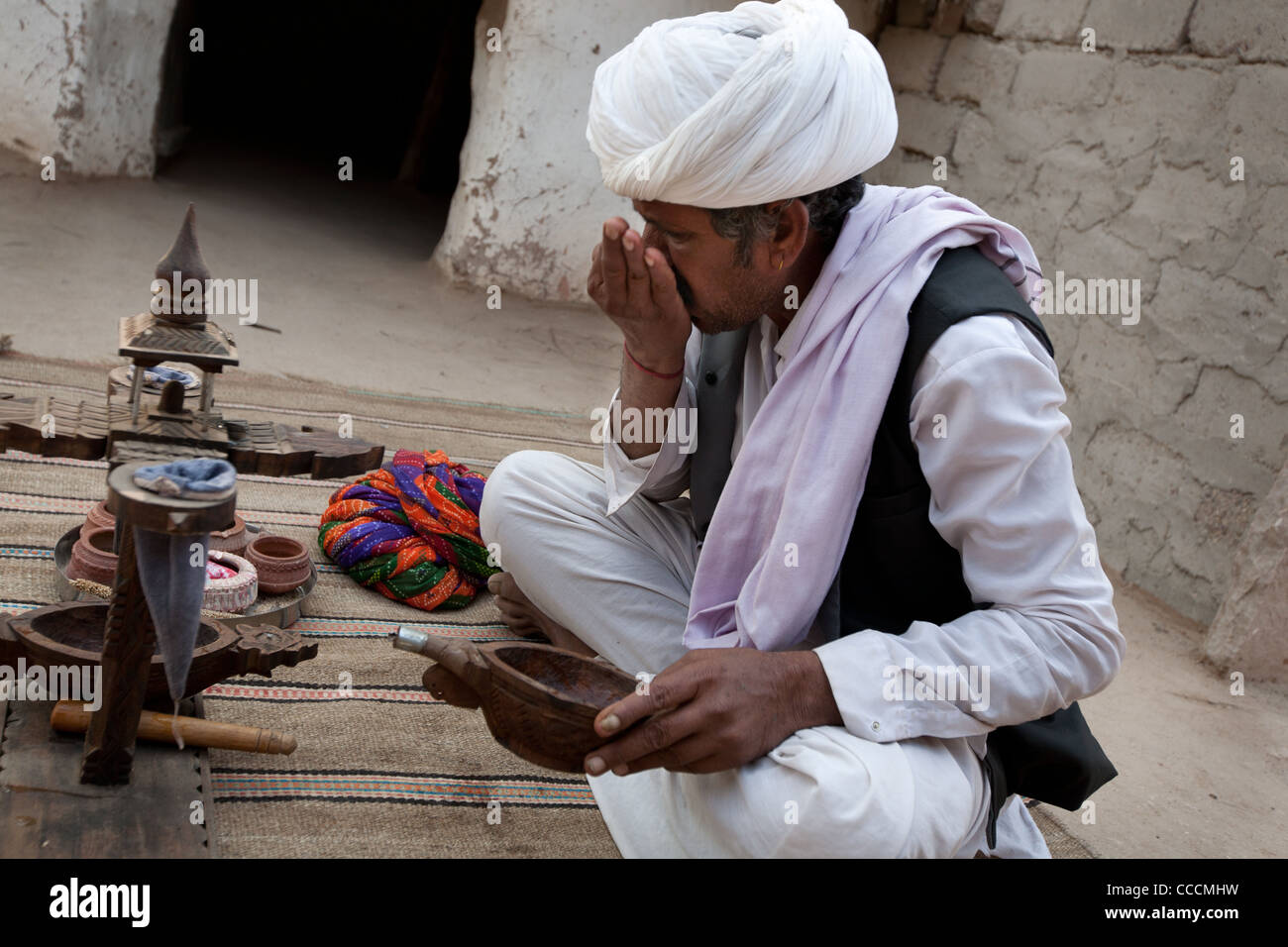 Anziano maschile in un villaggio di Bishnoi esegue una cerimonia di oppio, a Rajasthan, India. Foto Stock