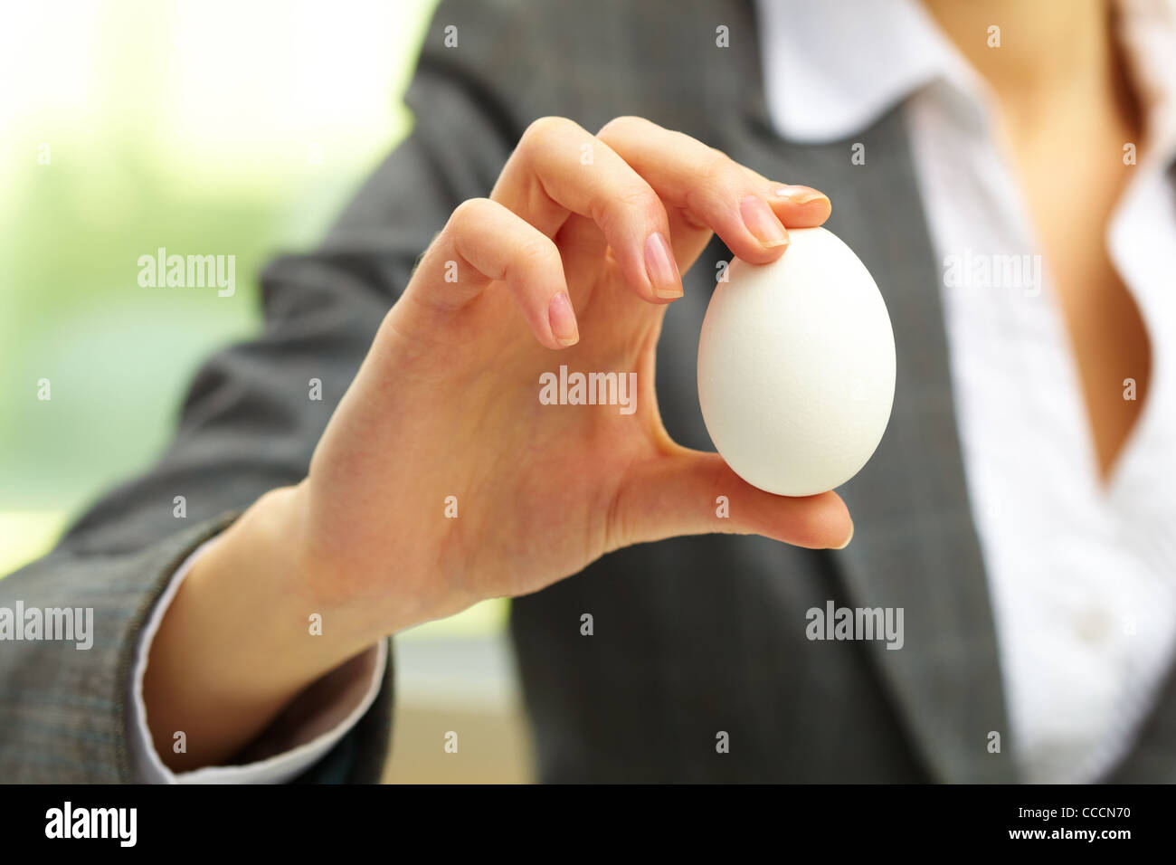 Close-up di uovo bianco in mano femmina Foto Stock
