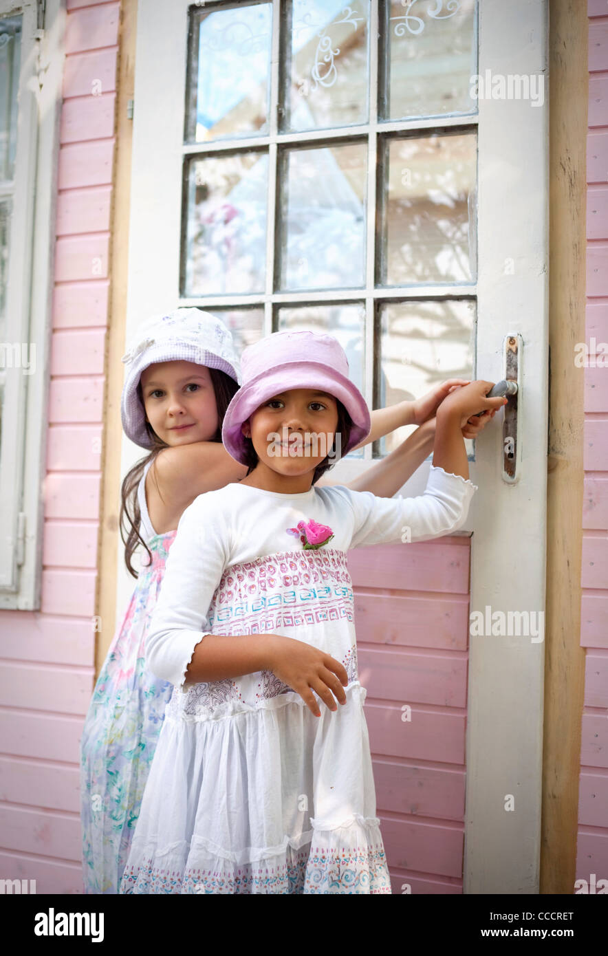 Sweet Little ragazze sulla porta della sua casa di bambola Foto Stock