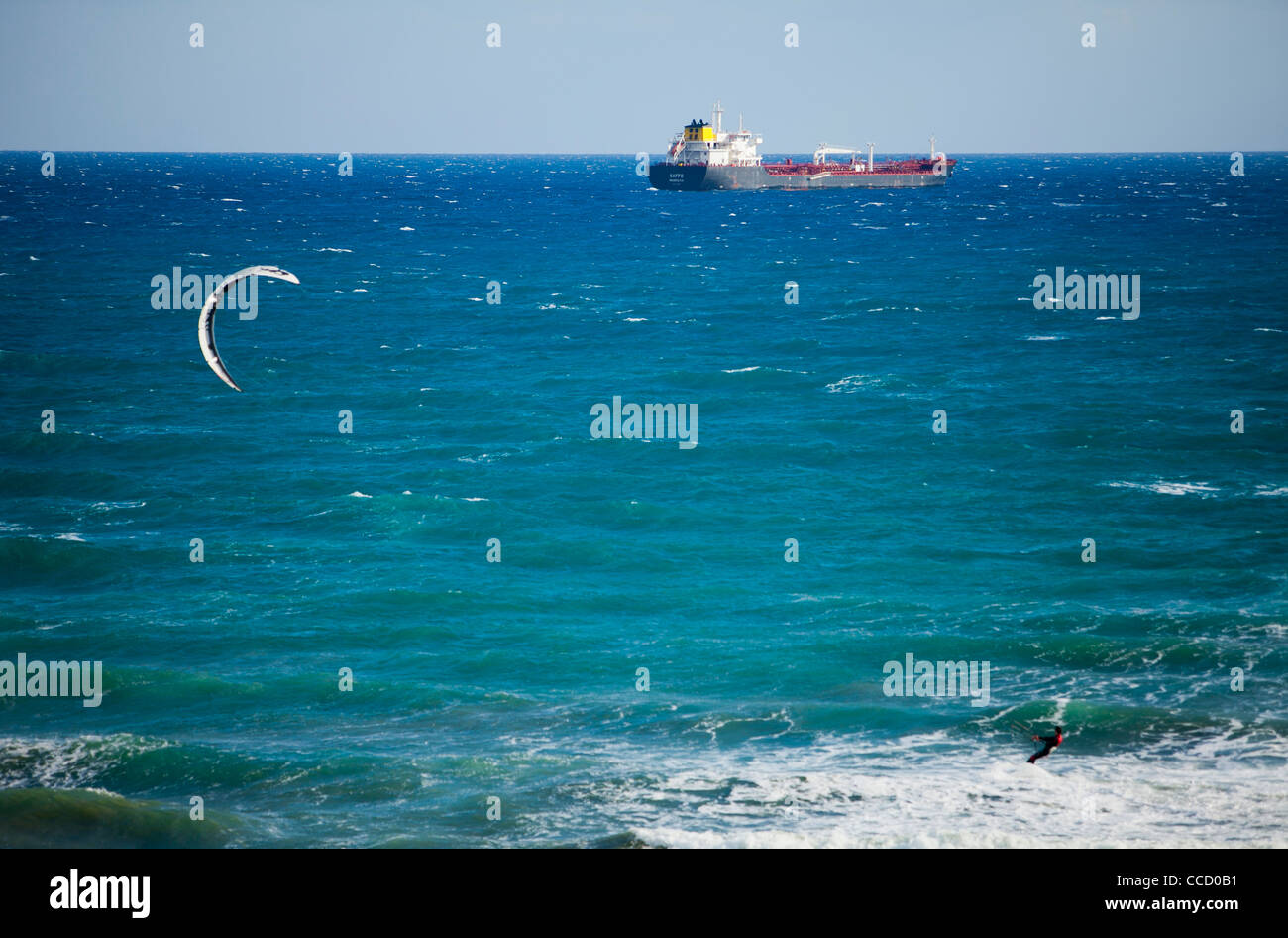 Kite surfer beach Larnaca a Cipro olio combustibile il trasporto di nave in background onde ventoso sport blu oceano mare esercizio divertente atleta Foto Stock