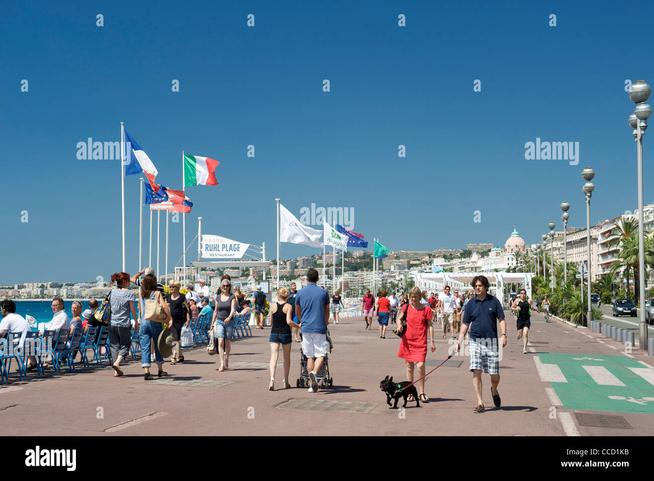 I pedoni a camminare lungo la passeggiata di Nizza sulla costa mediterranea nel sud della Francia. Foto Stock