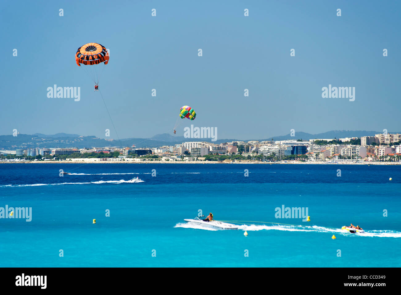 Barche a motore tirando parasailers nella Baia degli Angeli a Nizza sulla costa mediterranea nel sud della Francia. Foto Stock