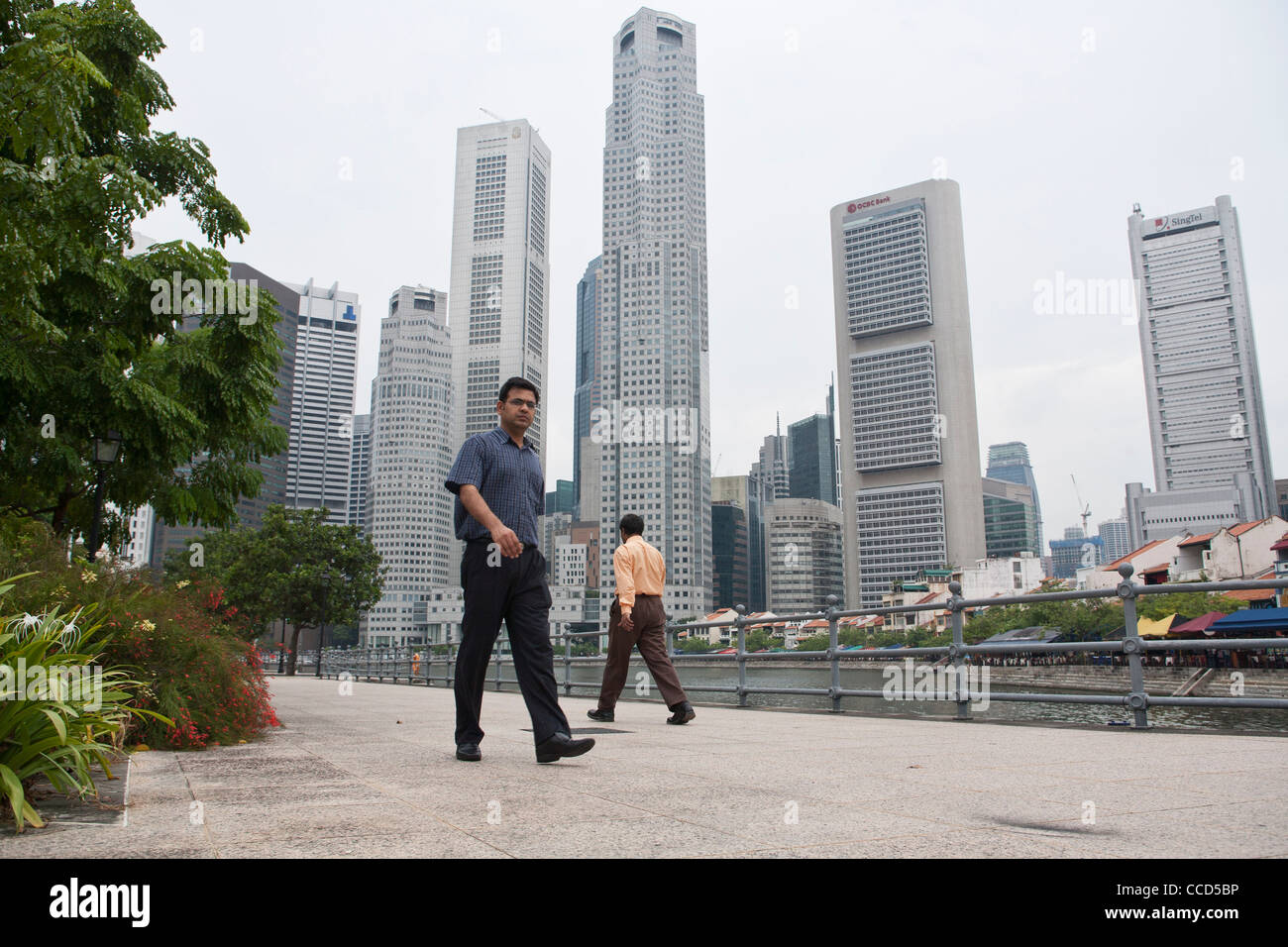 La gente a piedi passato il quartiere centrale degli affari di Singapore Foto Stock
