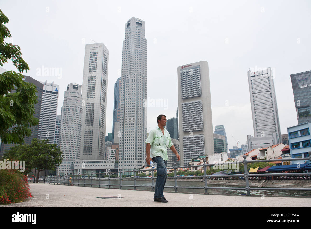 Un uomo cammina passato il quartiere centrale degli affari di Singapore Foto Stock