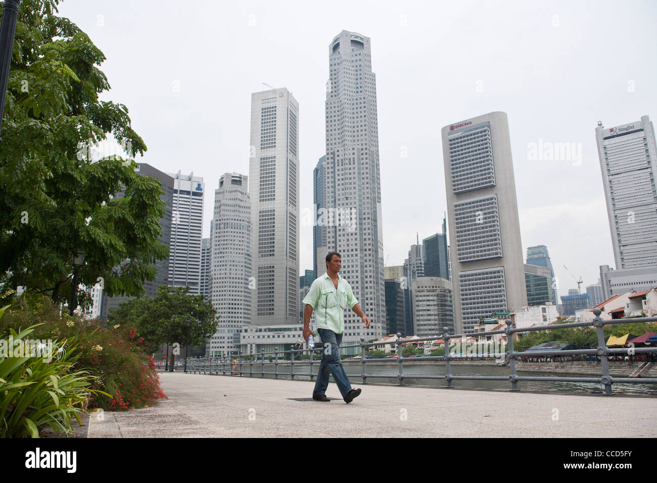 Un uomo cammina passato il quartiere centrale degli affari di Singapore Foto Stock